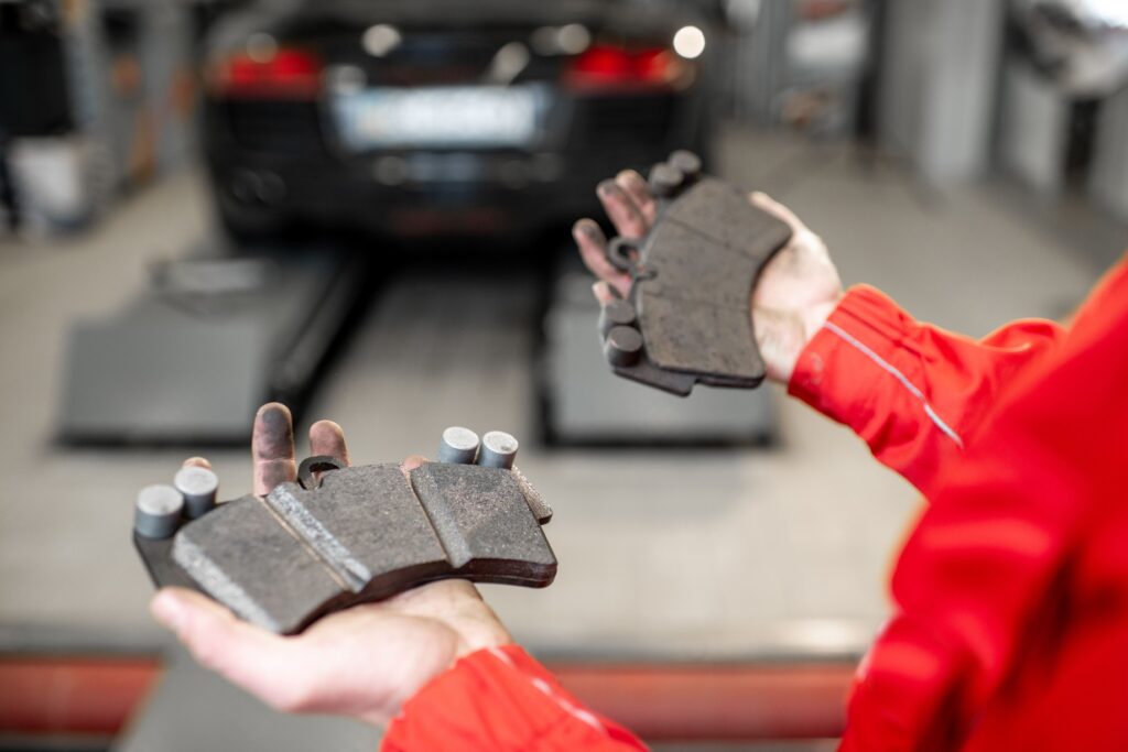 Kohler Motors mechanic holding worn brake pads