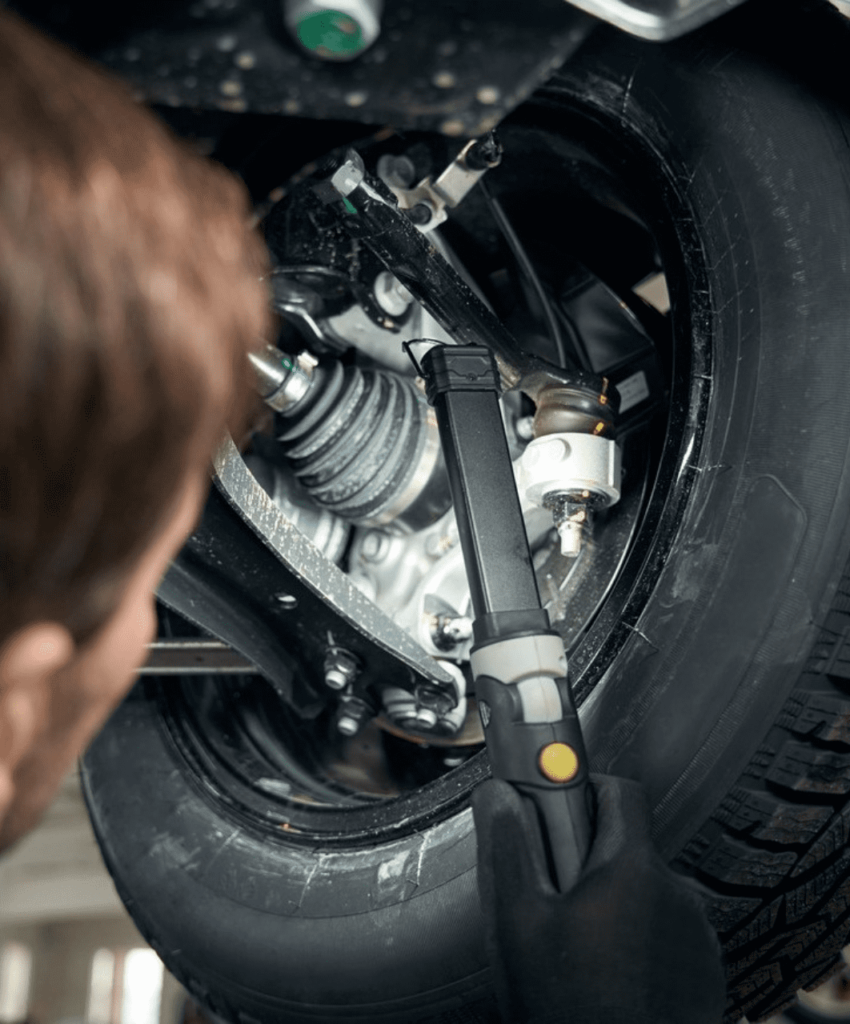 Kohler Motors mechanic checking suspension underneath vehicle